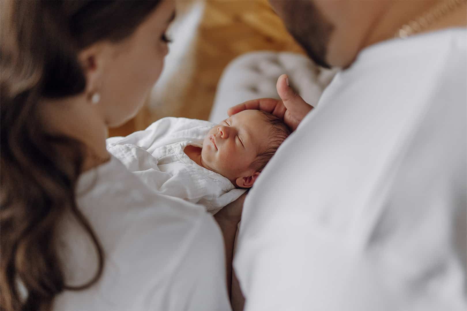 Betreuungspersonen halten ein schlafendes Neugeborenes behutsam im Arm.