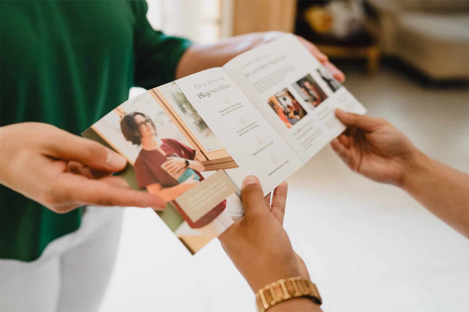 Broschüre mit Infos zur privaten Pflege und Pflegekraft in der Hand.