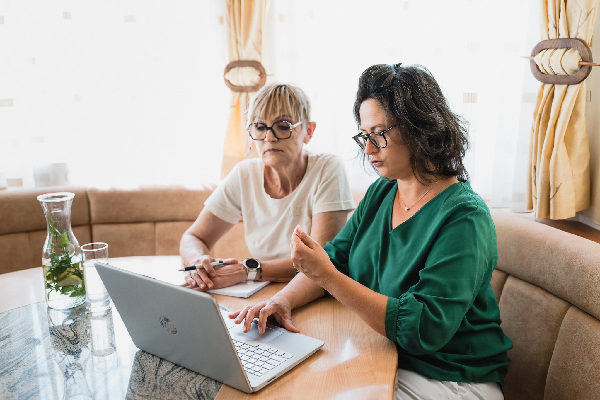 Zwei Teammitglieder von Nursing on Level besprechen Inhalte gemeinsam an einem Laptop.